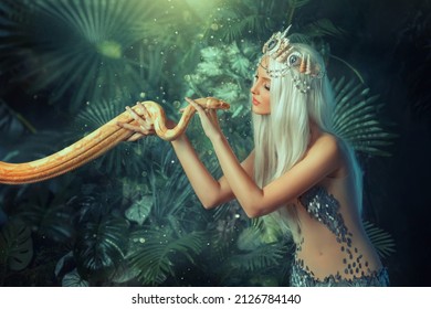 Legend mythical Nagga woman queen sea touch holds milk snake in hands. Blond girl long white flowing hair. Backdrop landscape tropical plants, green leaves. Girl mermaid silver color sexy art costume