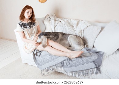 leggy girl is resting on a divan with her Persian greyhound dog