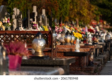 Legionowo, Poland - October 19, 2021: Catholic cemetery, candles and flowers on graves on a sunny autumn day before All Saints Day on November 1.