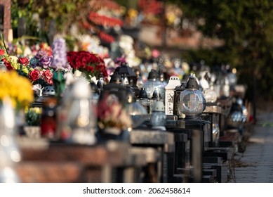 Legionowo, Poland - October 19, 2021: Catholic cemetery, candles and flowers on graves on a sunny autumn day before All Saints Day on November 1.