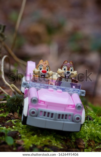 Lego mini figures chip and chap\
drive through\
the forest in a pink\
Cadilac