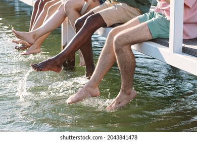 Legs Of Barefoot Friends Splashing Water In Lake While Enjoying Summer Rest