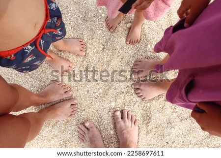 Legs of the beautiful whole family on the sand near the sea background