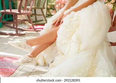 Legs of bride in funny wedding shoes