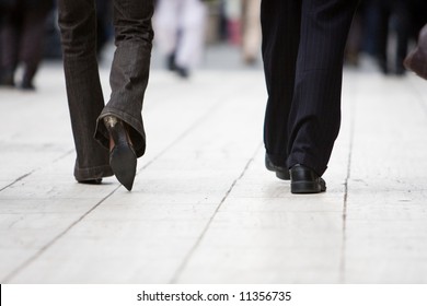 The Legs Of A Business Man And Woman Walking Away From The Camera