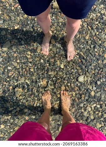 Legs of a coupe in the transparent sea water