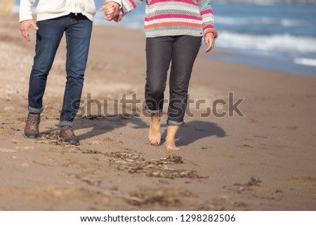 legs of couple walking on the beach