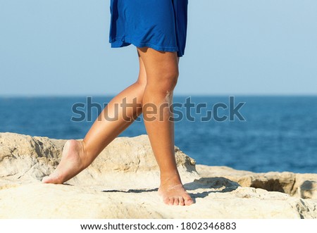 Legs of dancer on natural background.Side close up view of unrecognizable woman feet legs, barefoot girl standing outdoor on the rocks, performing on a rock ground.