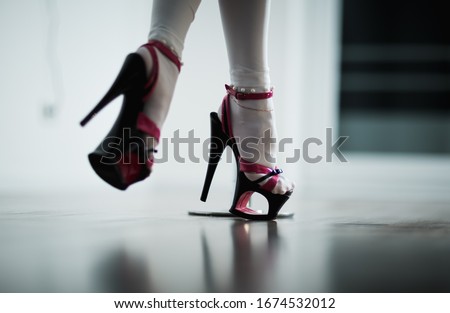 The legs of a dancer on a pylon in striptease shoes. Dance photo