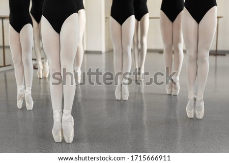 Legs of a dancer on white pointer shoes in the choreographic hall. Young ballerina