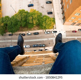Legs dangling from a rooftop