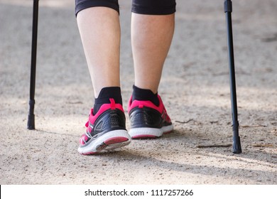 Legs Of Elderly Senior Woman In Sporty Shoes Practicing Nordic Walking, Concept Of Healthy Sporty Lifestyles In Old Age