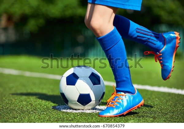 Beine eines Fußballspielerjungen in Stiefeln mit Stockfoto Beine eines Fußballspielerjungen in Stiefeln mit Stockfoto