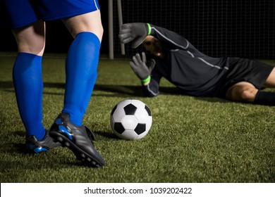 Legs Of A Footballer Player Kicking The Ball And Diving Goalie Trying To Save The Goal