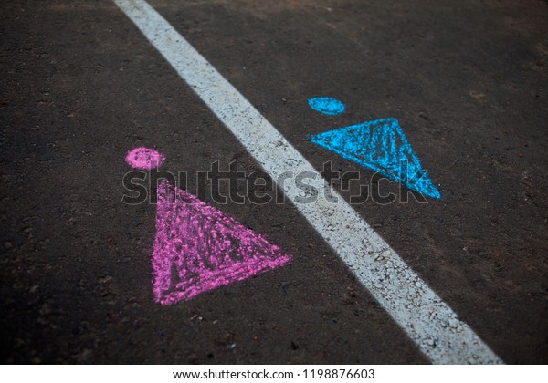 Legs with\
gender symbol on asphalt, gender\
concept