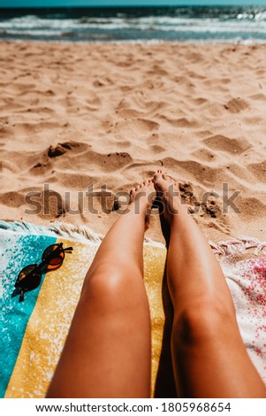 Legs of a girl lying on the beach.