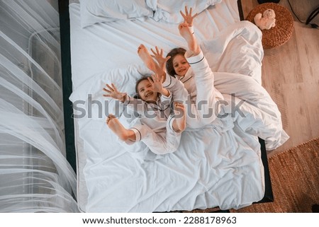 Mother reading book to her sons in the bed