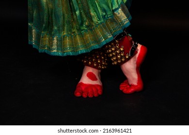 Legs of an Indian dancer. Oriental transport. Close-up of walking on a black background