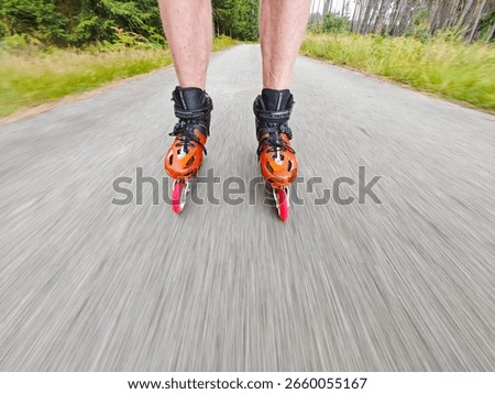 Legs in inline skates boots are moving on abandoned asphalt road in forest. 7th of July 2019, Hradcany, Czech Republic