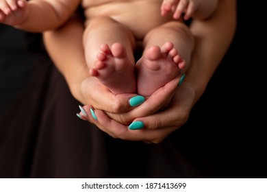 Beine des kleinen Mädchens in den Händen der Mutter
