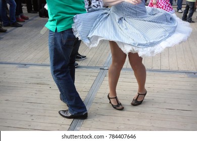 Legs Of Male And Female Rock 'n Roll Dancers On Wooden Floor