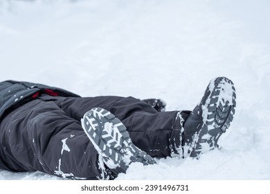 the legs of a man lying in a winter forest, a frozen man found. found a man in the winter in the forest - Powered by Shutterstock