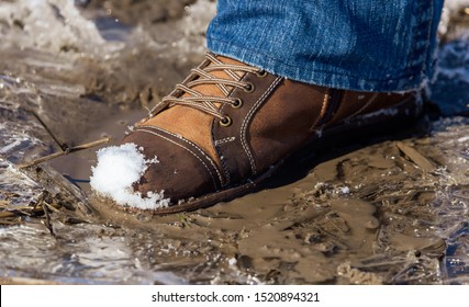 Legs of a man in shoes and jeans on the snow in winter.