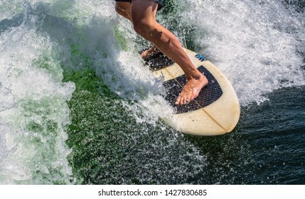 Legs Of Man Wake Surfing Behind Boat In The Summer