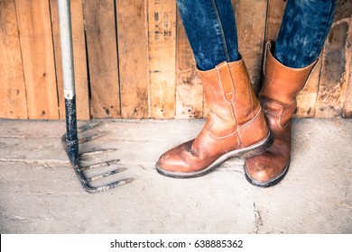 Legs of man wearing boots standing in barn