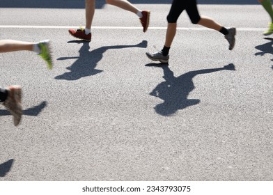 legs of marathon runners running on asphalt - Powered by Shutterstock