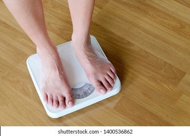 Legs Of Men Standing On Scales Weight. Concept Of Health And Weight Loss.