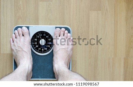 Legs of men standing on scales weight background fitness room. Concept of healthy lifestyle and sport