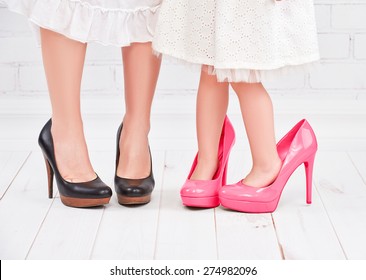 legs mother and daughter little girl fashionista in pink shoes on high heels