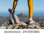 Legs of a mountaineer woman in a mountain top, in the background the great sugarloaf mountain, Wicklow Ireland