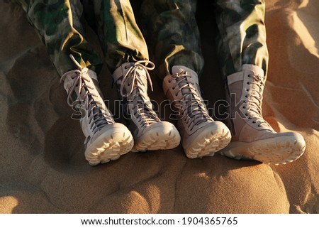 Legs of people in beige boots and khaki clothes. Caucasus, Russia