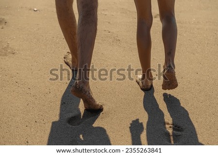 Legs of people walking along the beach. Selective focus. Sea.