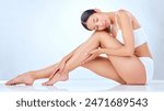 Legs, relax and Asian woman in studio for hair removal, cleaning and skin care for waxing. Underwear, model girl and pride for dermatology, laser treatment and cosmetics by white background with glow