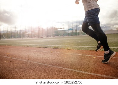 Legs of a runner Running along the stadium tracks close-up . Men's workout sunset jog workout Welness concept. - Shutterstock ID 1820252750