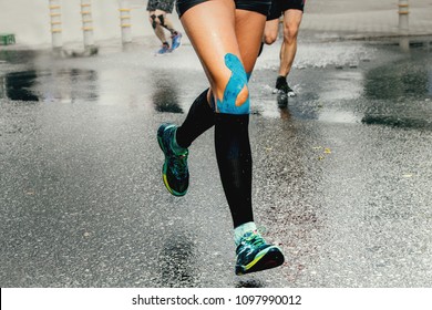 Legs Runner Woman With Kinesio Tape And Compression Socks