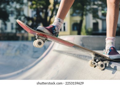 Legs of a skater girl on the skateboard before doing a drop in at the skate park bowl - Powered by Shutterstock