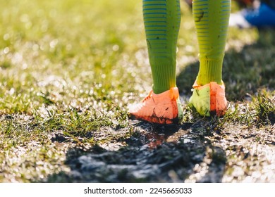 Legs of Soccer Player Standing in Muddy Grass Pitch. Football Clothes Covered With Mud. Junior Level Football Game in Rainy Day