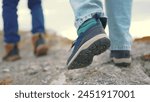The legs of tourists go through the mountains on a journey. adventure mountains trekking concept. a group of tourists legs walk along top of the mountain rocks lifestyle close-up shoes