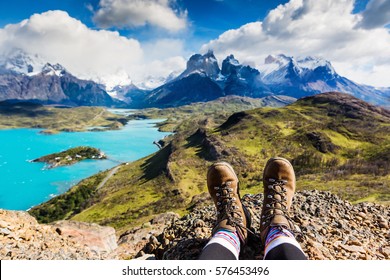 Legs of traveler sitting on a high mountain top in travel. Freedom concept. Patagonia, Chile - Powered by Shutterstock