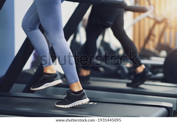 Legs of two\
girl friends working out on\
treadmill