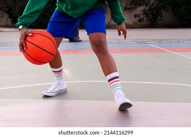 legs of an unrecognizable woman playing on a basketball court outdoors, concept of urban sport in the street, copy space for text - Powered by Shutterstock