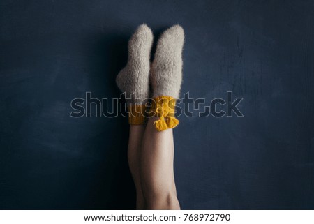 Legs wearing  Christmas socks, posing in festive decoration