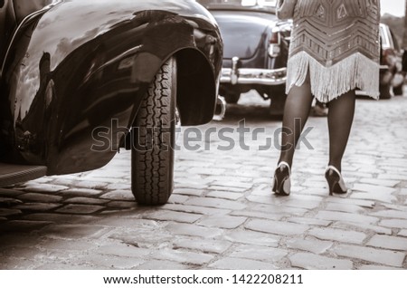 Legs of woman getting out of old auto. young woman in high heels shoes, retro style.