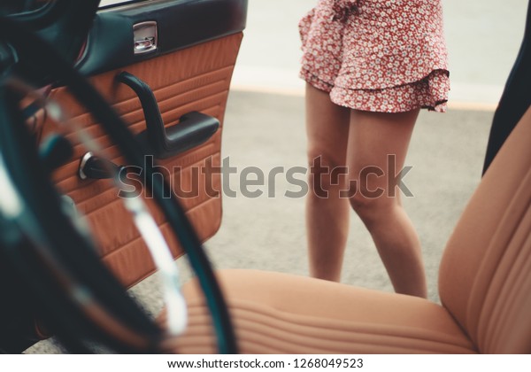 Legs of woman and old car concept\
abduction or kidnapping of woman and gender\
violence