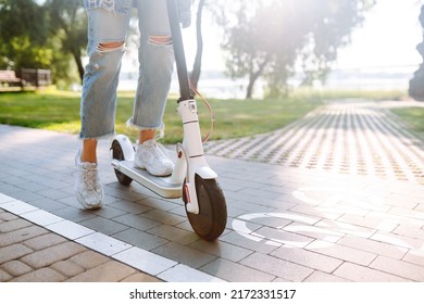 Piernas de mujer montando patineta eléctrica. Concepto de transporte ecológico.