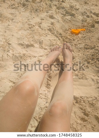 Legs of a woman in the sand on a beach